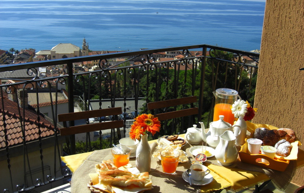 Отдых в кафе на террассе на курорте в Пьетра Лигуре, Италия