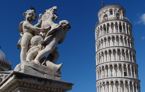 Статуя на фоне башни в Пизе, Италия