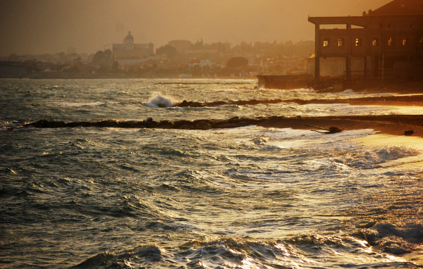 Закат на пляже на курорте в Пьетра Лигуре, Италия