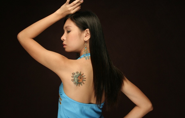 Женщина в голубом платье с тату 