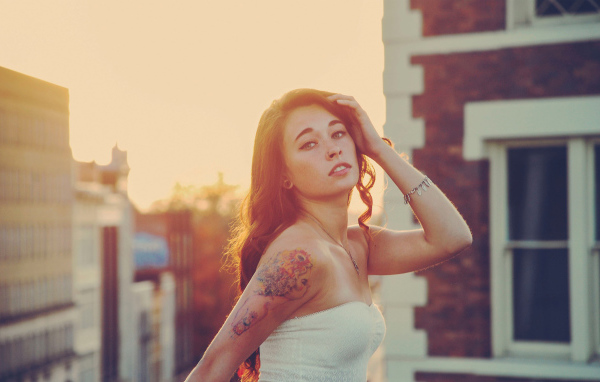 Girl at sunset with a tattoo on his shoulder