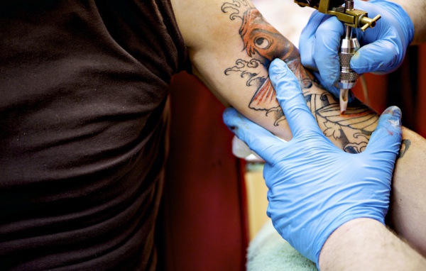 Девушке делают татуировку