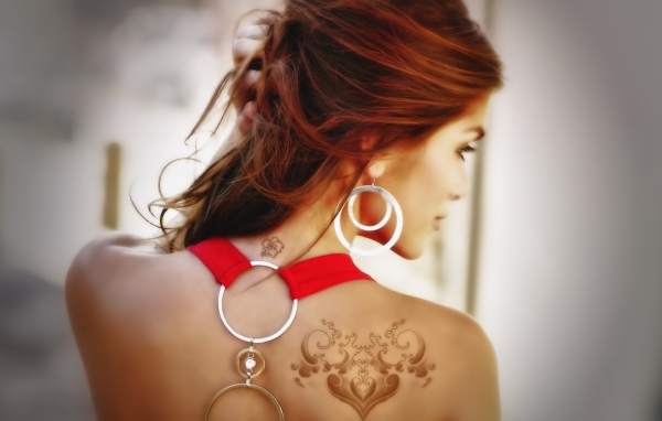Девушка с татуировками на плече и шее