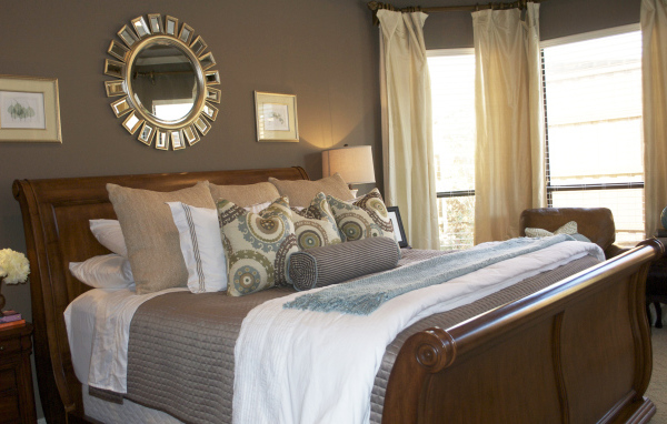 Круглое зеркало над кроватью в спальне