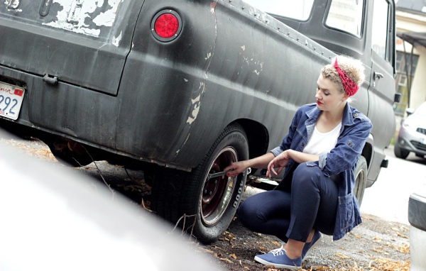 Девушка чинит автомобиль