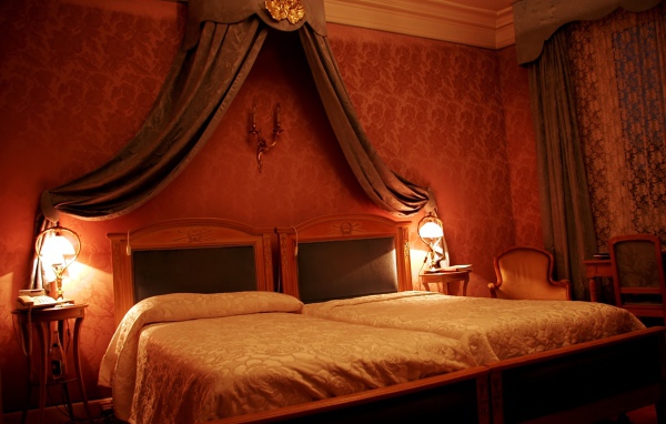 Кровать под вензелем в спальне