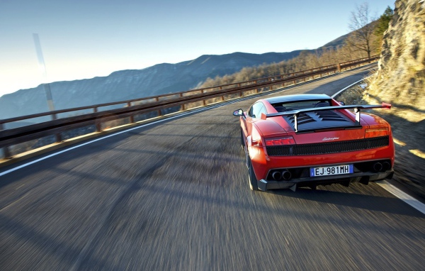 Красный гоночный автомобиль на горной дороге