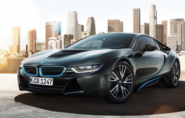 Спортивный черный БМВ на фоне мегаполиса