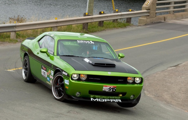 Зеленый автомобиль Dodge Challenger SRT8 на повороте