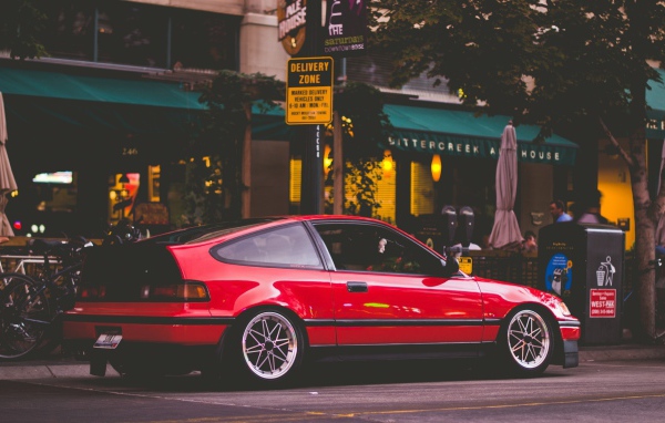 Красная Honda CRX стоит у уличного кафе