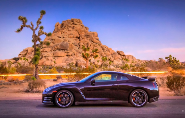 Автомобиль Nissan GT-R на фоне скалы