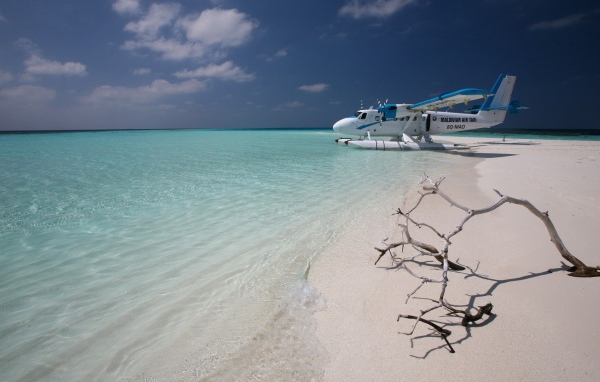 Самолет сел на воду у белого пляжа