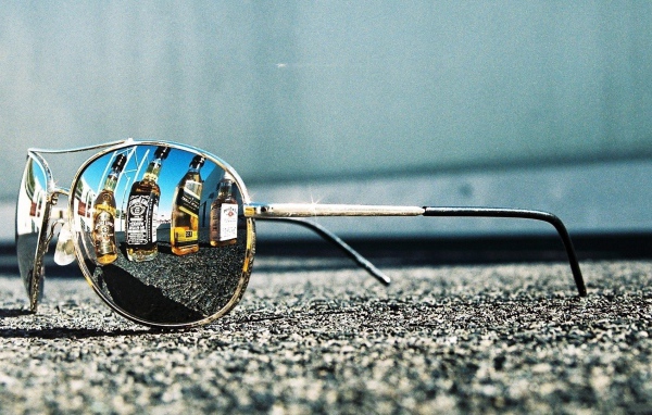 Бутылки с алкоголем отражаются в очках