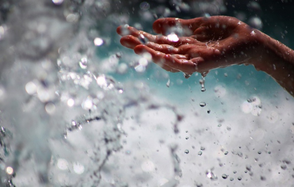 Человек ловит воду рукой