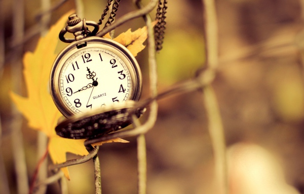 Часы на цепочке и осенний лист