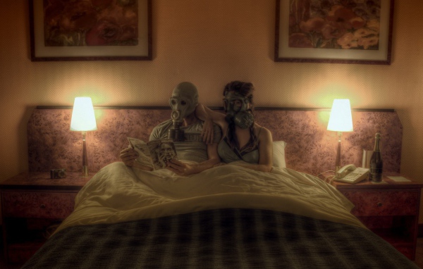 Семейная пара лежит в кровати в масках