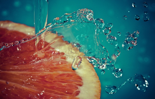 Вода льется на срез грейпфрута