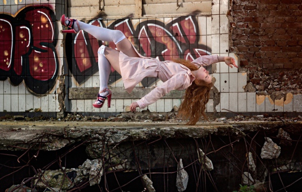 Девушка выполняет трюк на фоне граффити