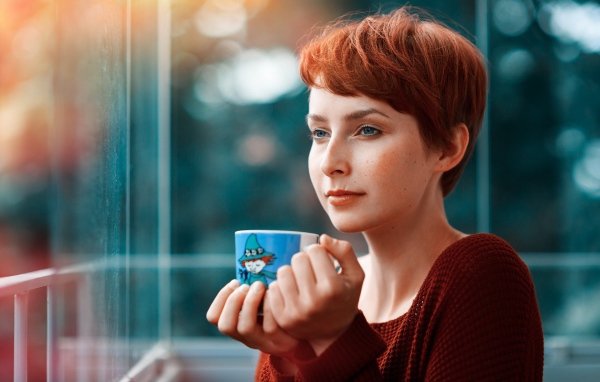 Девушка с короткими волосами пьет кофе