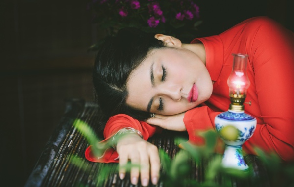 Азиатка спит положив голову на руки