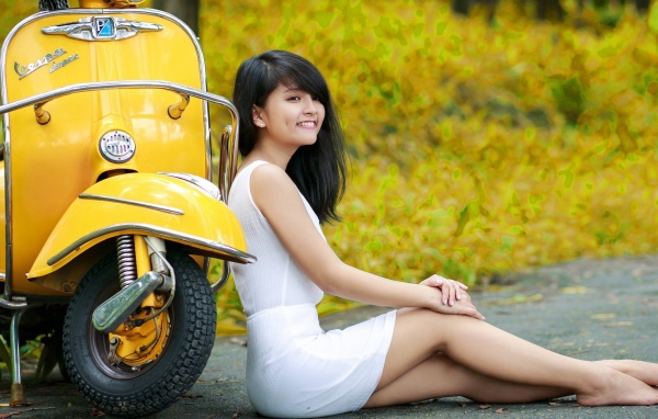 Азиатская девушка у желтого мотороллера