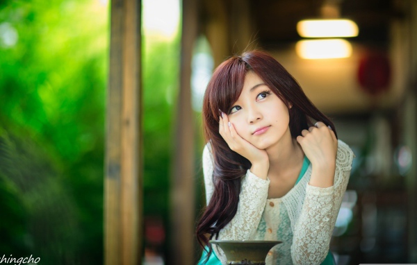 Азиатская девушка задумчиво смотрит вверх