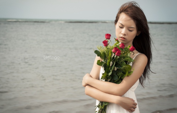 Азиатка держит в руках букет роз