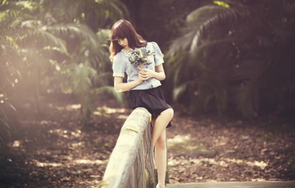 Азиатка с букетом на поручне моста