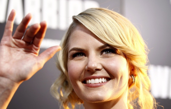 Блондинка улыбается и машет