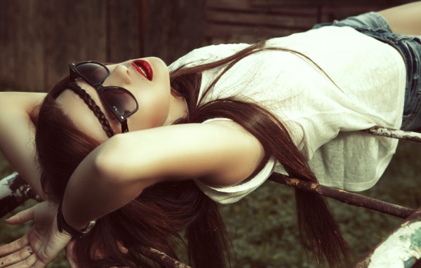 Брюнетка в темных очках смотрит в небо