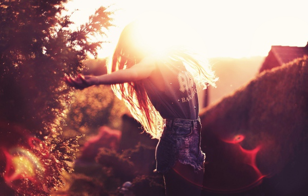 Девушка радуется солнцу