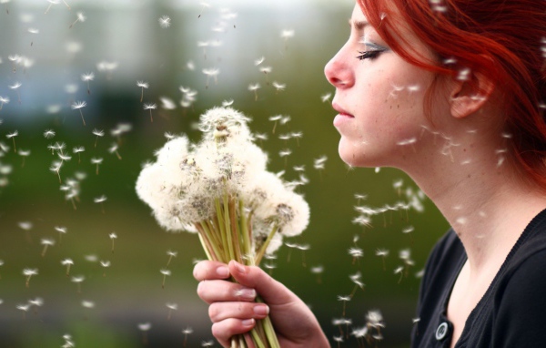 Девушка держит в руках букет одуванчиков