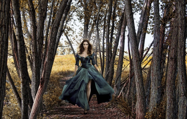Девушка в черном платье среди деревьев