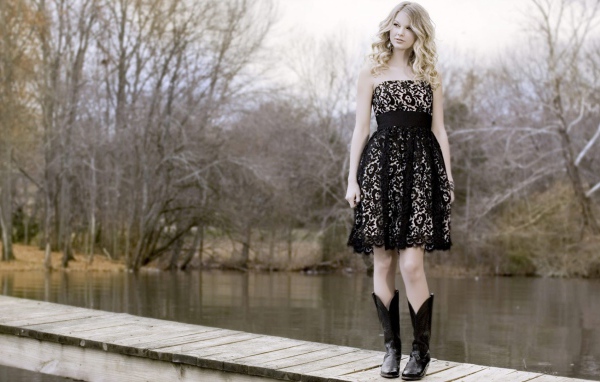 Девушка в черном платье и кожаных сапогах