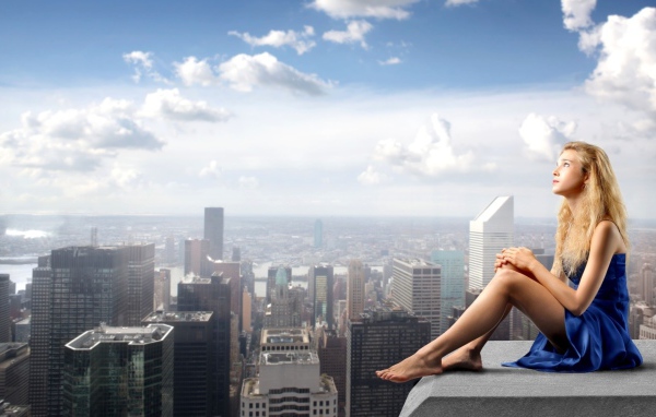 Девушка в голубом платье сиlит на краю крыши