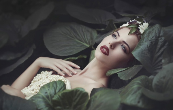 Девушка лежит в больших листьях