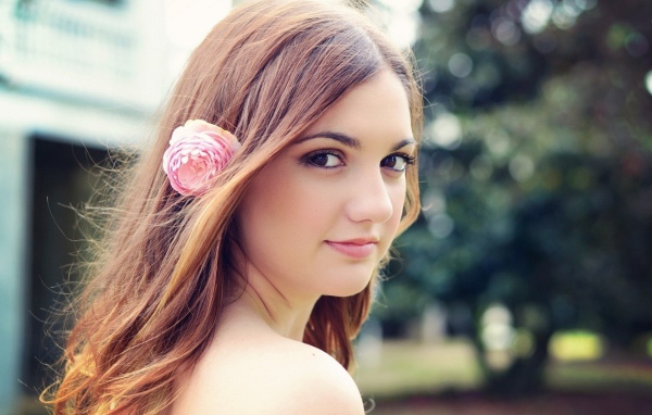Девушка модель с розовым цветком в волосах