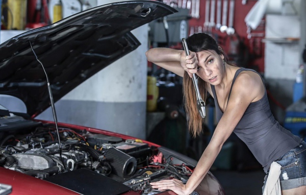 Девушка ремонтирует автомобиль