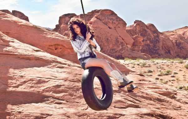 Девушка катается на качелях