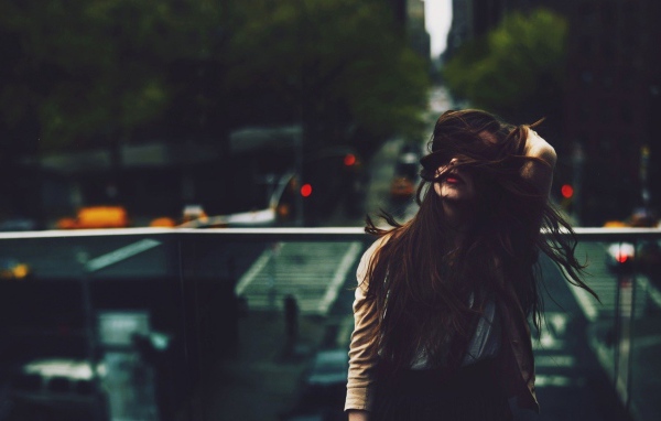 Девушка стоит на мосту над автострадой