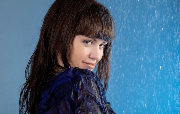 Девушка стоит под струей воды