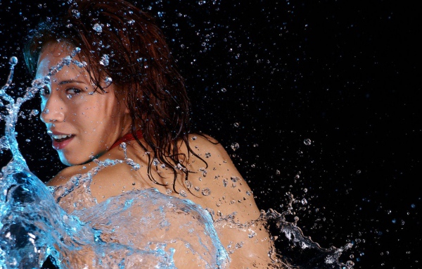Девушка с голой спиной среди брызг воды