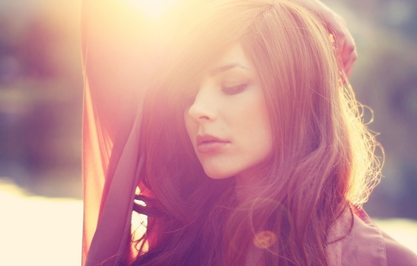 Девушка с каштановыми волосами в лучах солнца