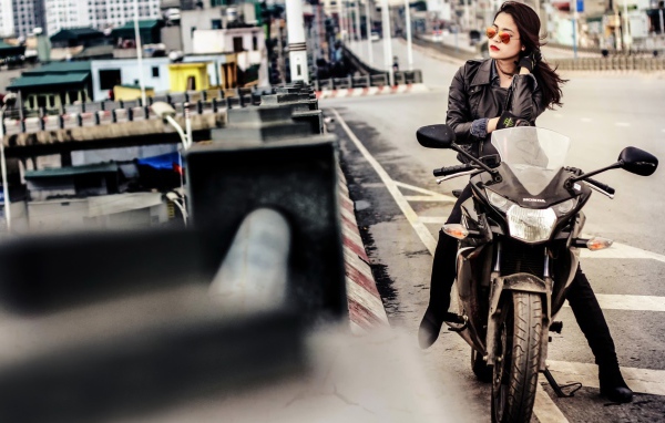 Девушка в темных очках сидит на мотоцикле