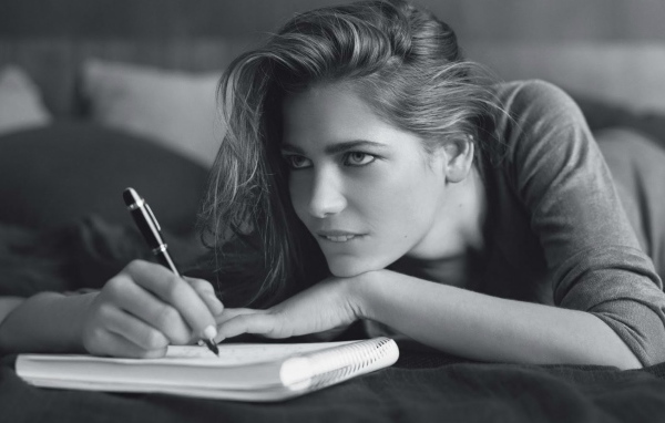 Девушка пишет в блокноте