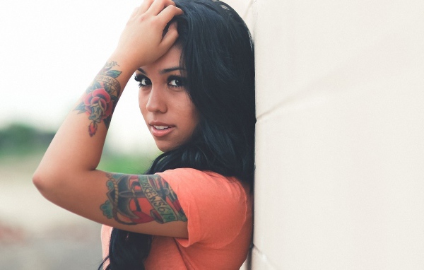 Страстная длинноволосая брюнетка прислонилась к стене