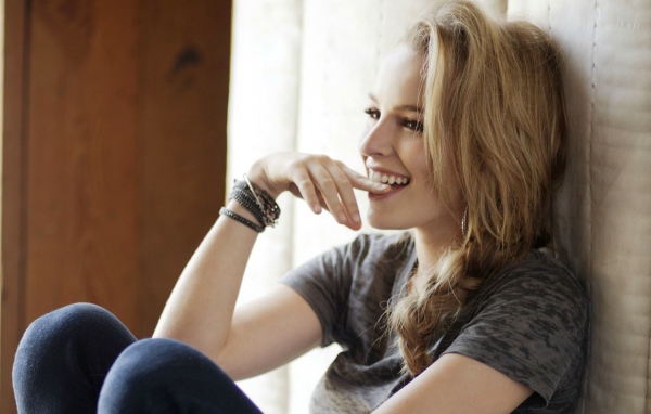 Смеющаяся блондинка приложила палец к губам