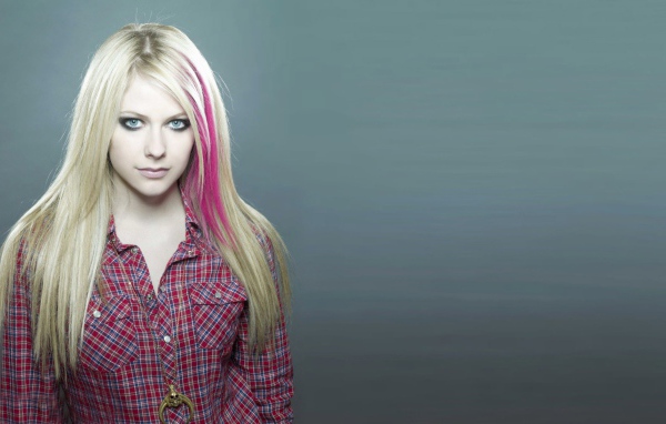 Розовая прядь волос у блондинки на сером фоне