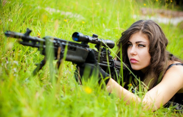Девушка снайпер залегла в траве