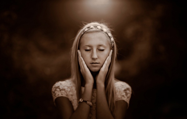 Девушка прикоснулась руками к лицу